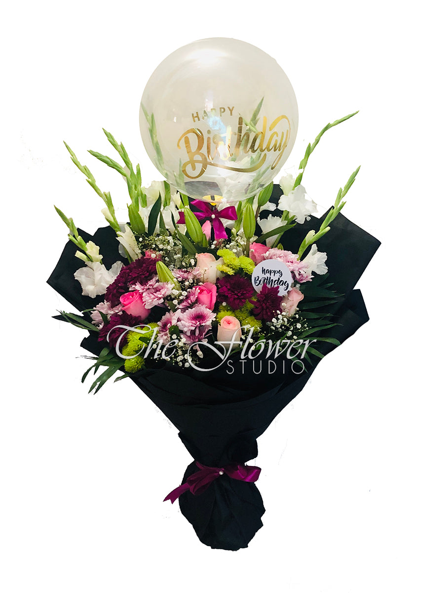Happy birthday bouquet of gladiolus, chrysanthemums, imported roses and tuberoses in a black wrap with a happy birthday balloon