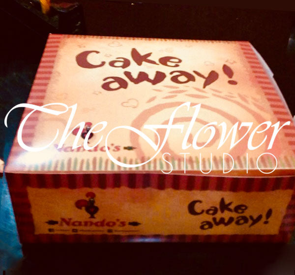 Nando's 4lbs chocolate malt cake box with 'Cake away!' text and 'The Flower Studio' branding.